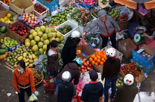 DA LAT, VIET NAM- FEBRUARY 8: People sell and buy fruits at farmers market in  Dalat, Viet Nam- February 8, 2013