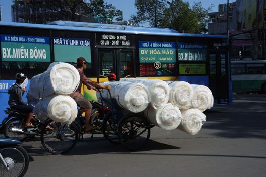 SAI GON, VIET NAM- JULY 10: Overloaded tranportation by pedicab on streets at Sai Gon, Viet Nam, July 10, 2013    