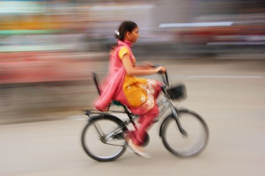 Indian woman riding bike, blurred, motion, Sadar Market, Jodhpur, Rajasthan, India