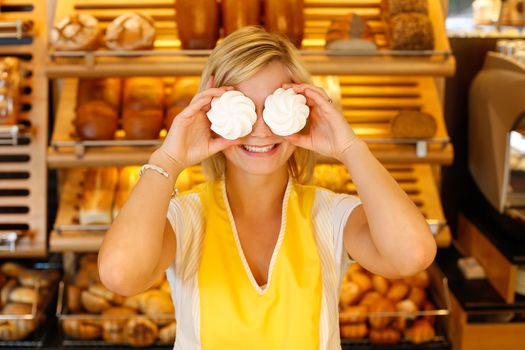 Bakery employee covers her eyes with meringue