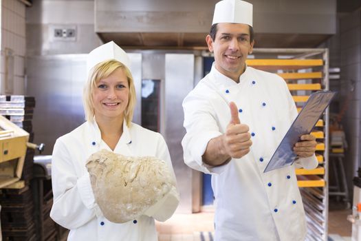 Baker presenting fresh bread dough in bakery or bakehouse
