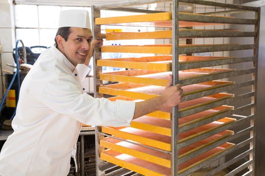 Baker with large rack for bread in a bakery