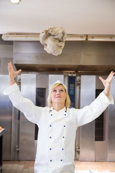 Baker throwing bread dough in bakery