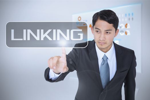 The word linking and unsmiling asian businessman pointing against technology interface