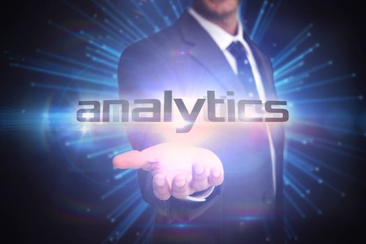 The word analytics and businessman presenting against abstract technology background