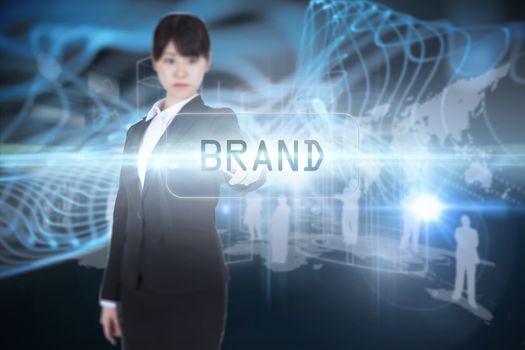 The word brand and focused businesswoman pointing against abstract glowing black background
