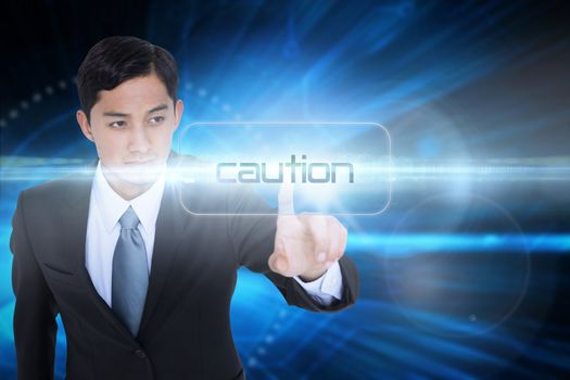 The word caution and unsmiling asian businessman pointing against blue technology background