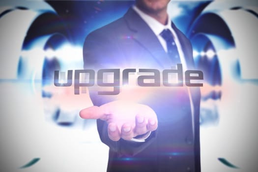The word upgrade and businessman presenting against abstract cloud design in futuristic structure