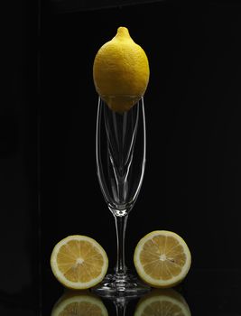 lemon on champagne glass over black background

