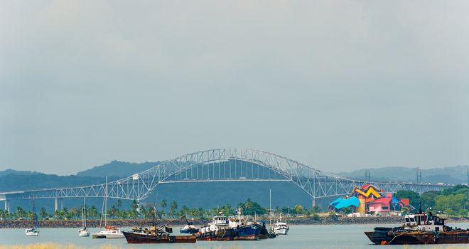  Boats waiting to pass thru Panama Canal and  on the background Carreterra Panamericana and bridge of the Americas on January 2, 2014.