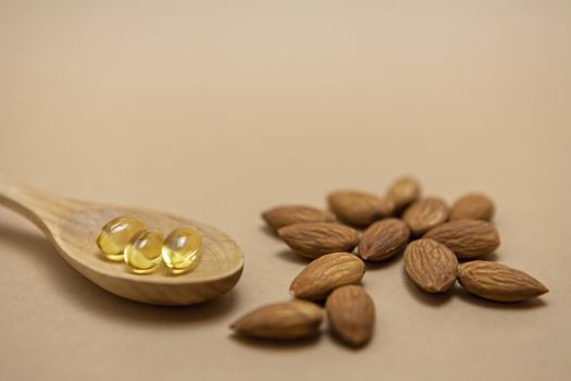 Almond oil in capsules isolated on brown background