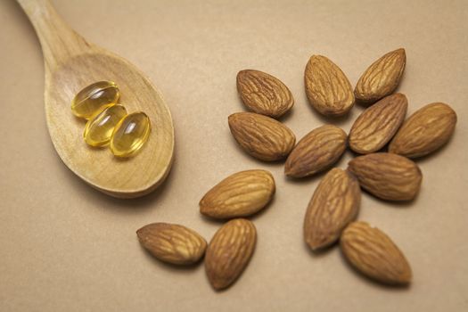 Almond oil in capsules isolated on brown background