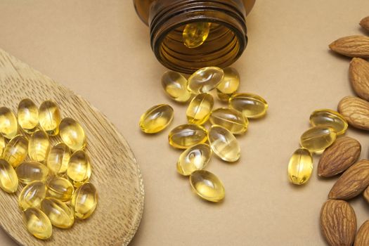 Almond oil in capsules isolated on brown background