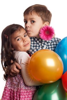 boy giving kiss to girl with flowers and balloons on white background