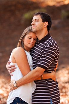 A young couple very much in love share a sweet embrace.