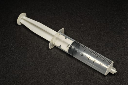 Black and White Syringe on a Dark Background