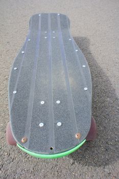 Vintage Style Longboard Black Skateboard on an Empty Asphalt Desert Road