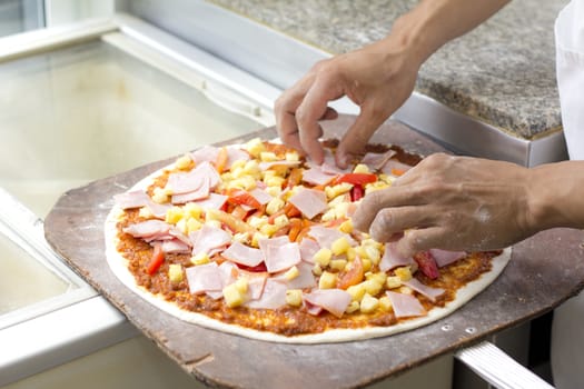 Close up chef baker making pizza at kitchen 