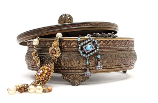 an old jewelery box with old jewels in it over a white background