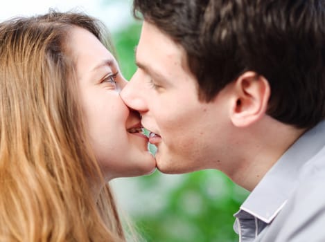 Attractive couple of lovers kissing itself lovingly on a sofa