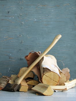 firewood and an axe over a old wall