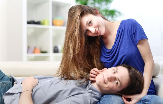 Cute man lengthened on the thighs of his girlfriend on a sofa in living-room