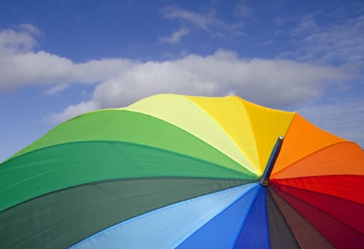 closeup of a colorful open umbrella over blue sky