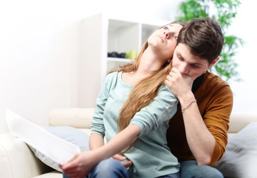 Young anxious couple consulting their bank account