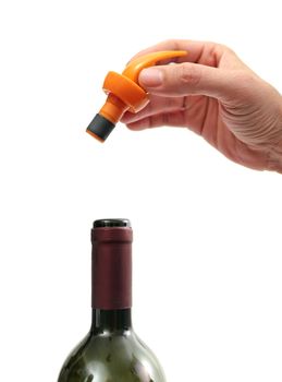 hand holding a wine preserver cap over white background with the top of a bottle