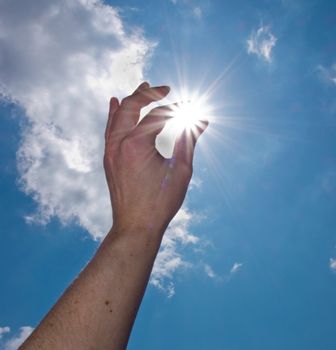 hand catch the sun on blue sky background