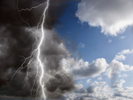 blue sunny sky and black clouds with lightning