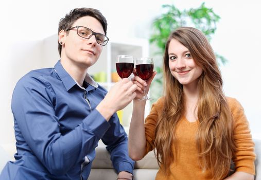 Very beautiful young couple toasting wine glasses