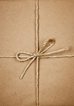 Gift package wrapped in brown paper tied with twine closeup