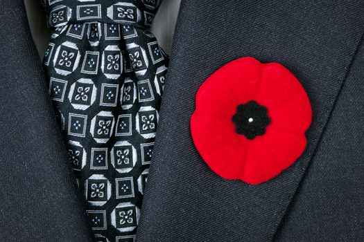 Red poppy lapel pin on suit jacket for Remembrance Day