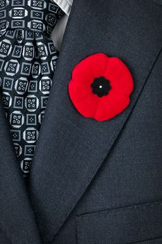 Red poppy lapel pin on suit jacket for Remembrance Day