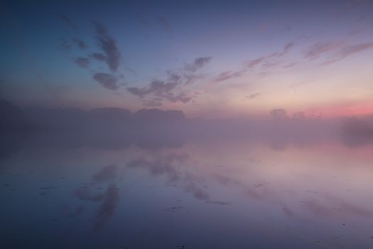 calm, warm misty sunrise in summer over river