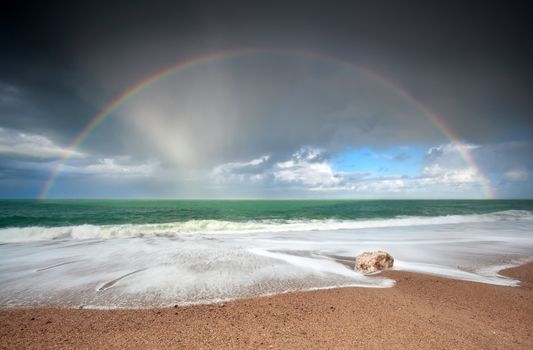 rainbow over Atlantic ocean waves on coast, Etretat, France