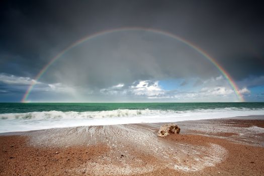 big beautiful rainbow over ocean waves after storm