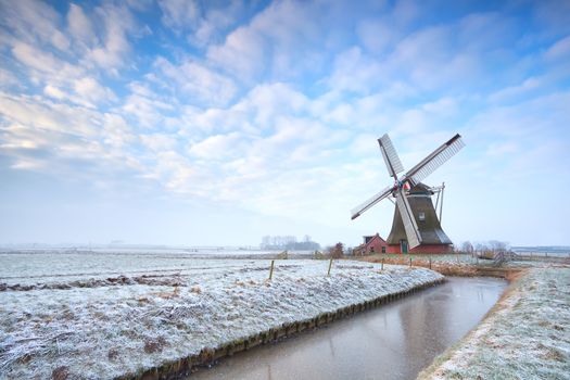 Dutch windmill in winter over blue sky, Holland