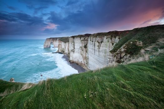 rainy sunrise over cliffs in Atlantic ocean, Etretat, France