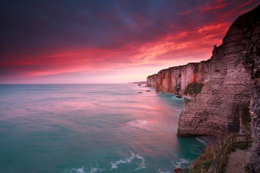 dramatic sunrise over ocean and cliffs, Etretat, France