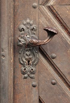 Old ornate decorative carved wooden door handle.