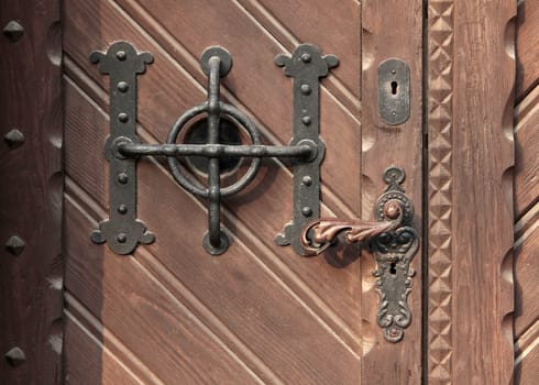 Old ornate decorative carved wooden door handle.