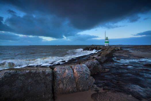 green lighthouse in dusk on North sea, Netherlands