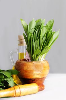 Cluster of fresh wild onion leaves in mortar and pestle