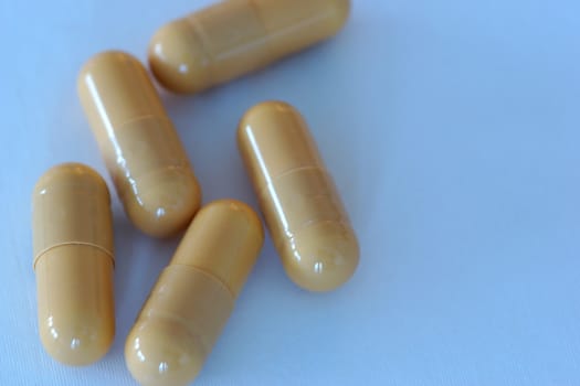 Multiple gel capsules containing a brown powdery substance
