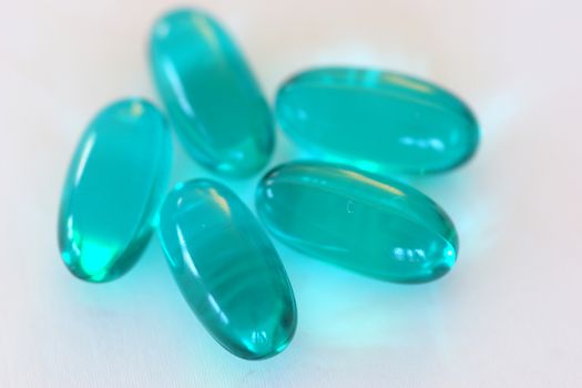 Multiple blue gel capsules containing medicine