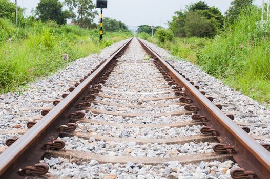 Railroad track into the distance and side of the grass