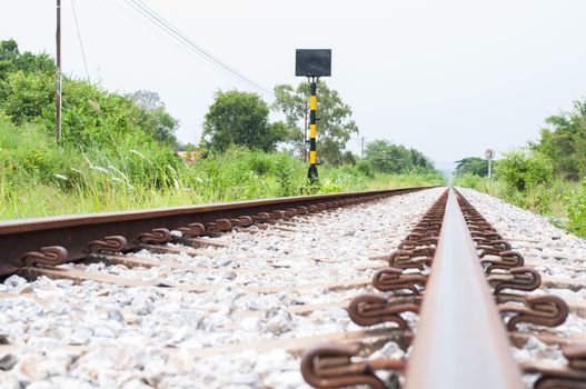 Railroad track into the distance and side of the grass