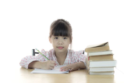 schoolgirl works on her homework, writing on notepad